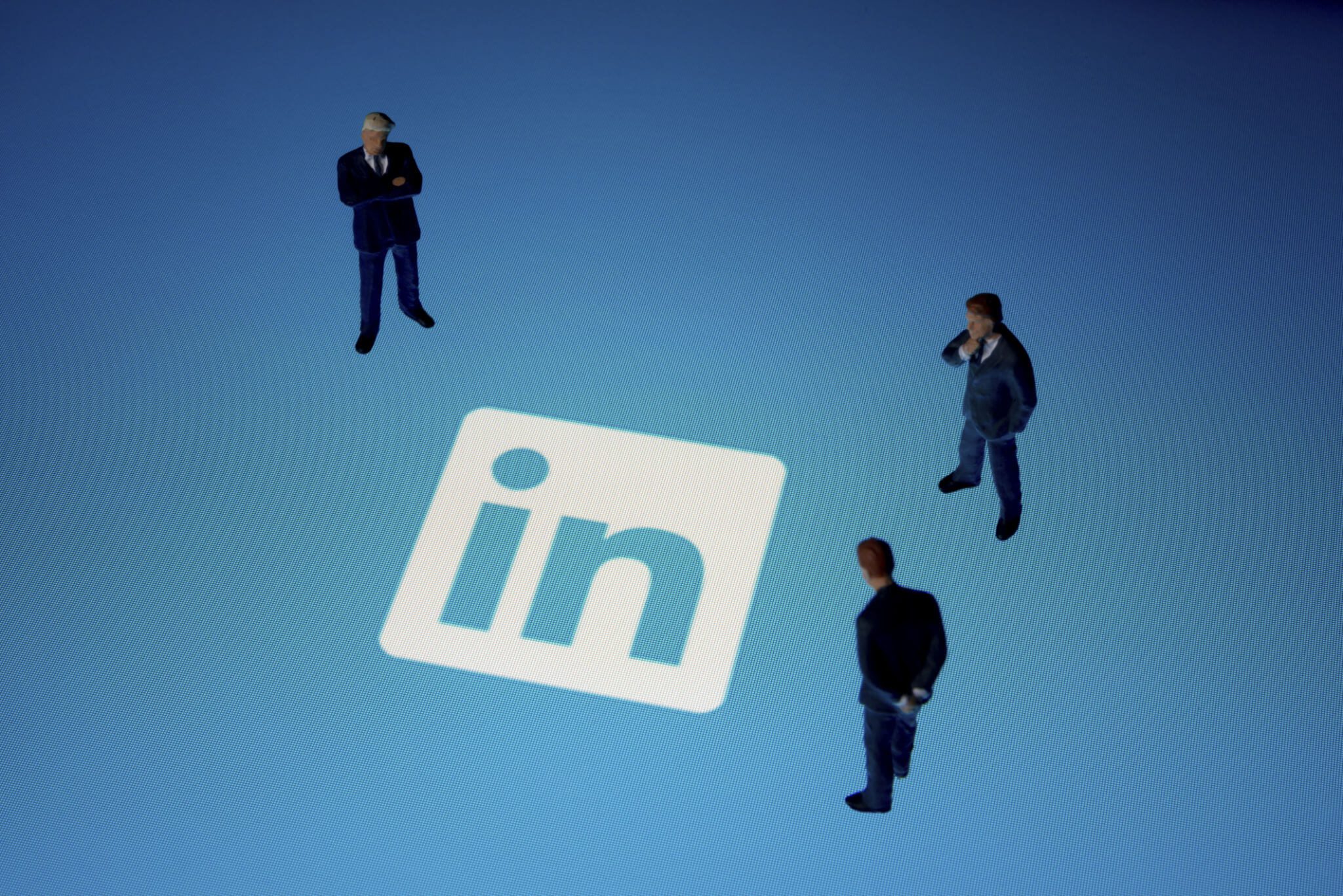 LinkedIn Logo and Three Businessmen Staring At it